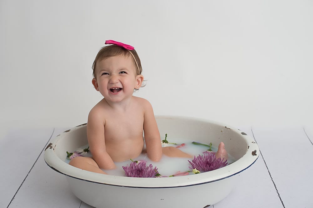 baby smiling sitting in a tub