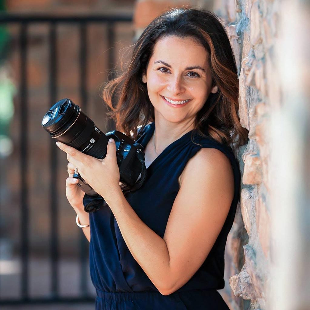 smiling woman holding a camera